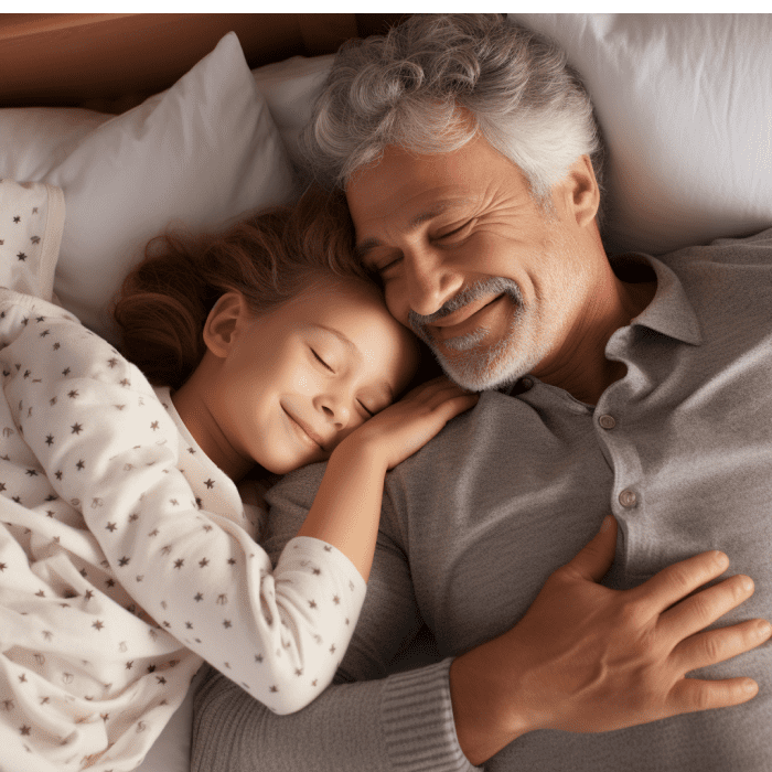 An old man sleeping calmly and happily with his young daughter hugging him as they both sleep comfortably and happily